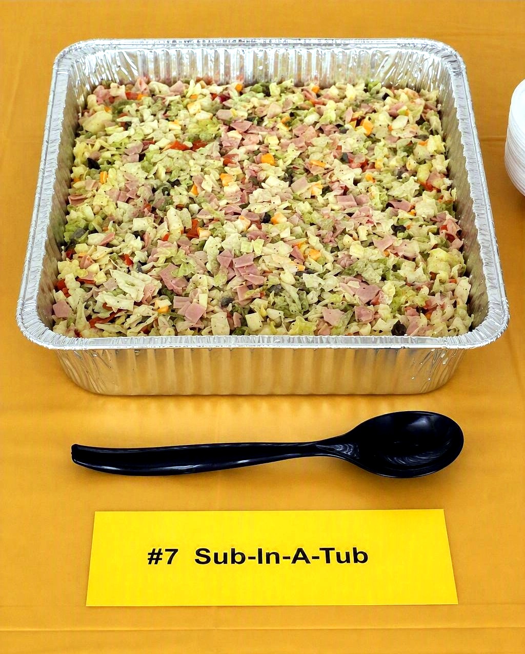 Image of sub in a tub on a yellow tablecloth